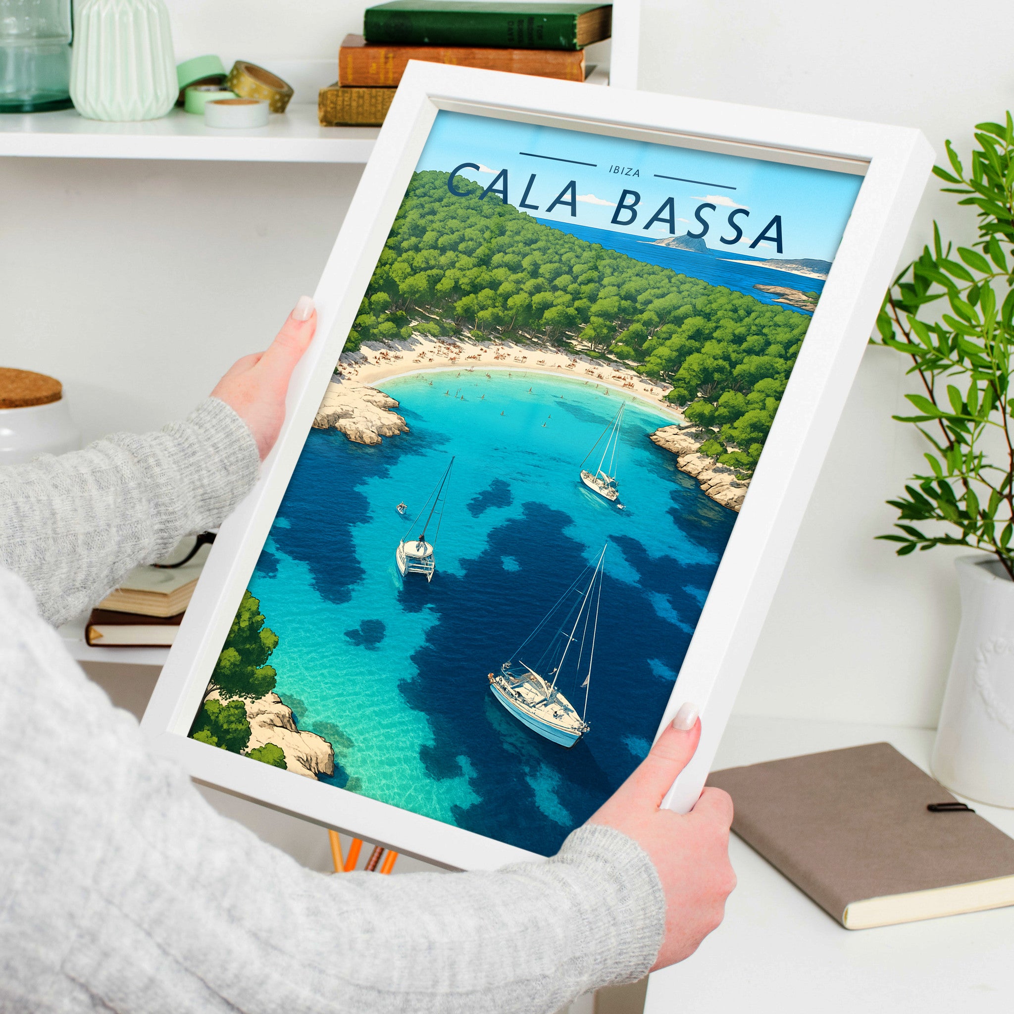 Cala Bassa Travel Poster in a white frame, held to show scale