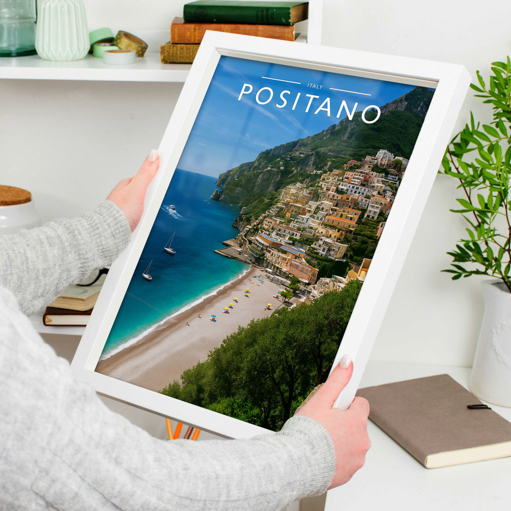 Positano Travel Poster in a white frame, held to show scale