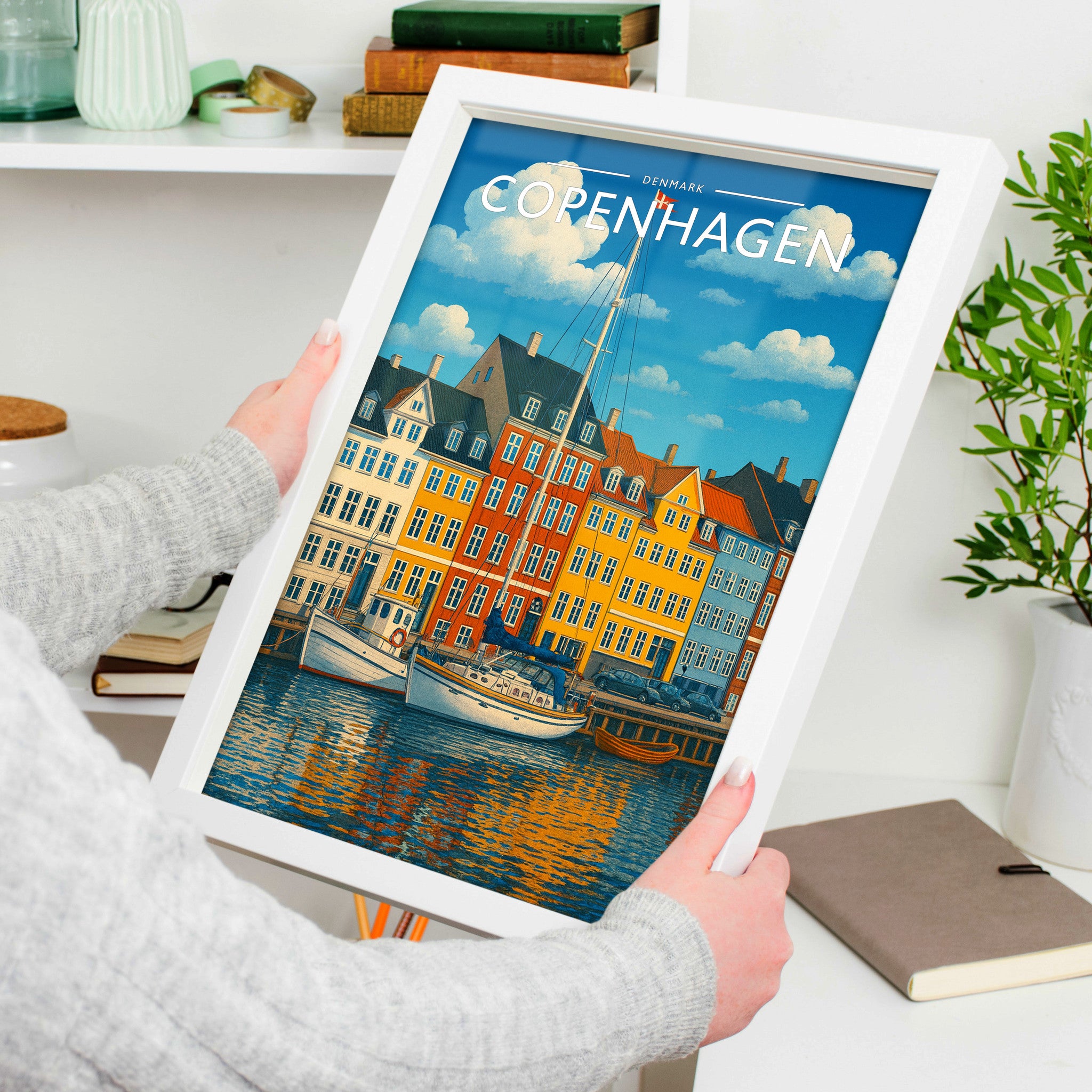 Copenhagen Travel Poster in a white frame, held to show scale