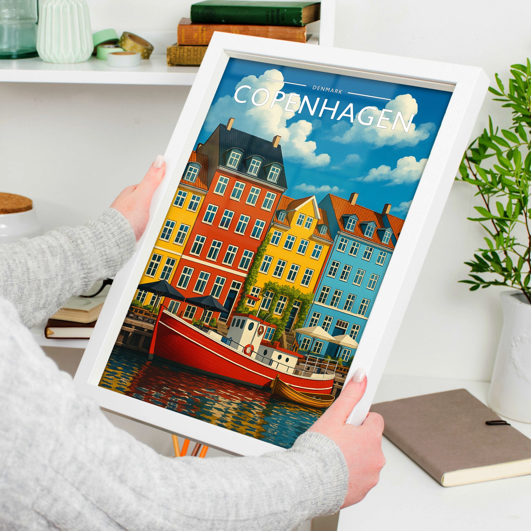 Copenhagen #2 Travel Poster in a white frame, held to show scale