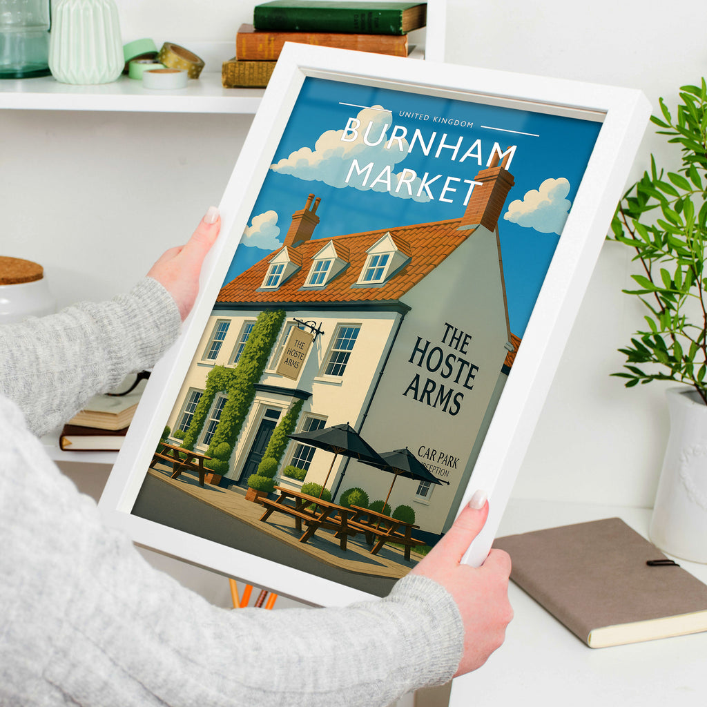 Burnham Market #2 Travel Poster in a white frame, held to show scale