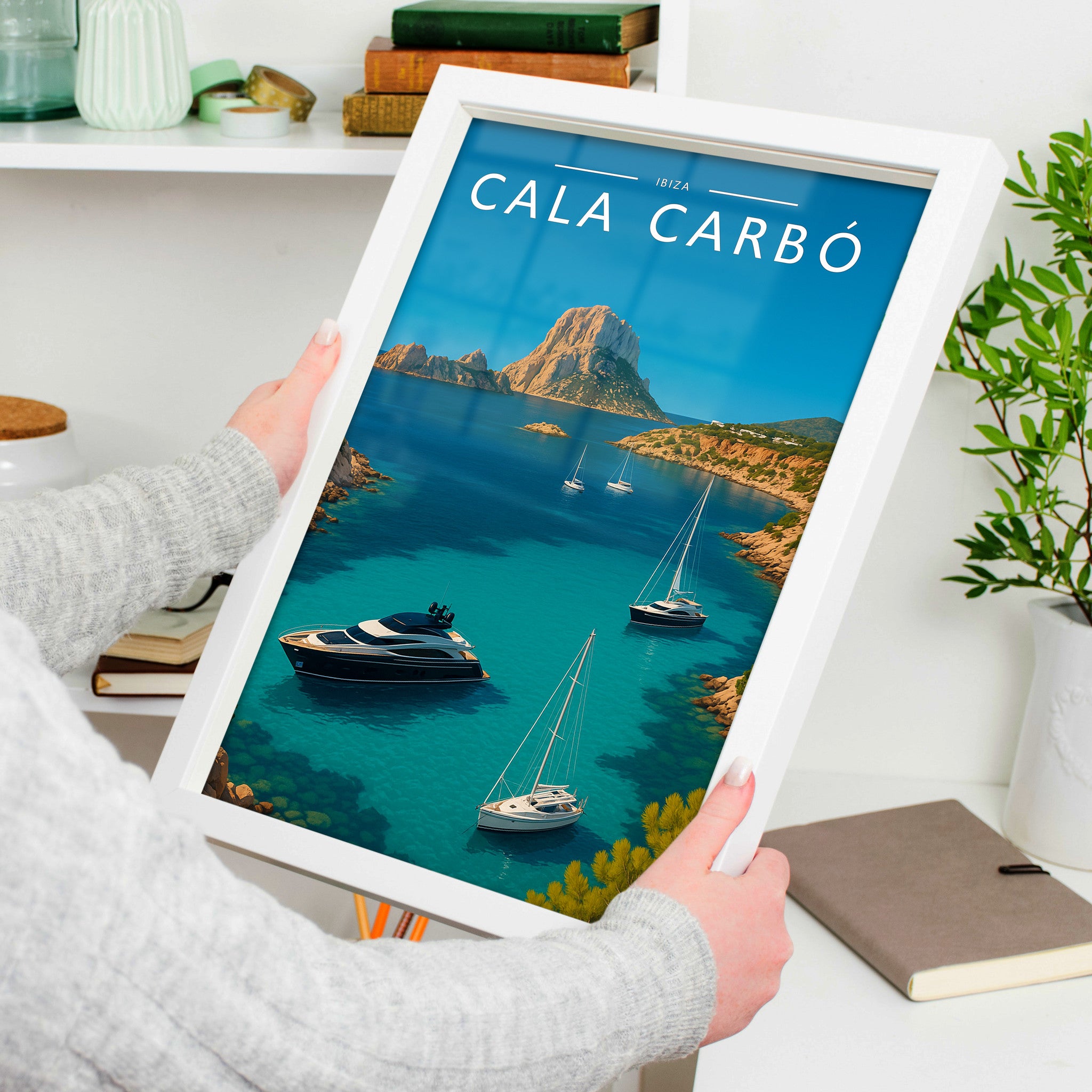 Cala Carbó Travel Poster in a white frame, held to show scale