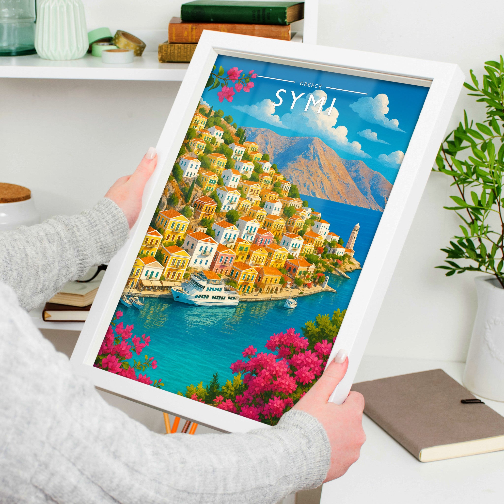 Symi Travel Poster in a white frame, held to show scale