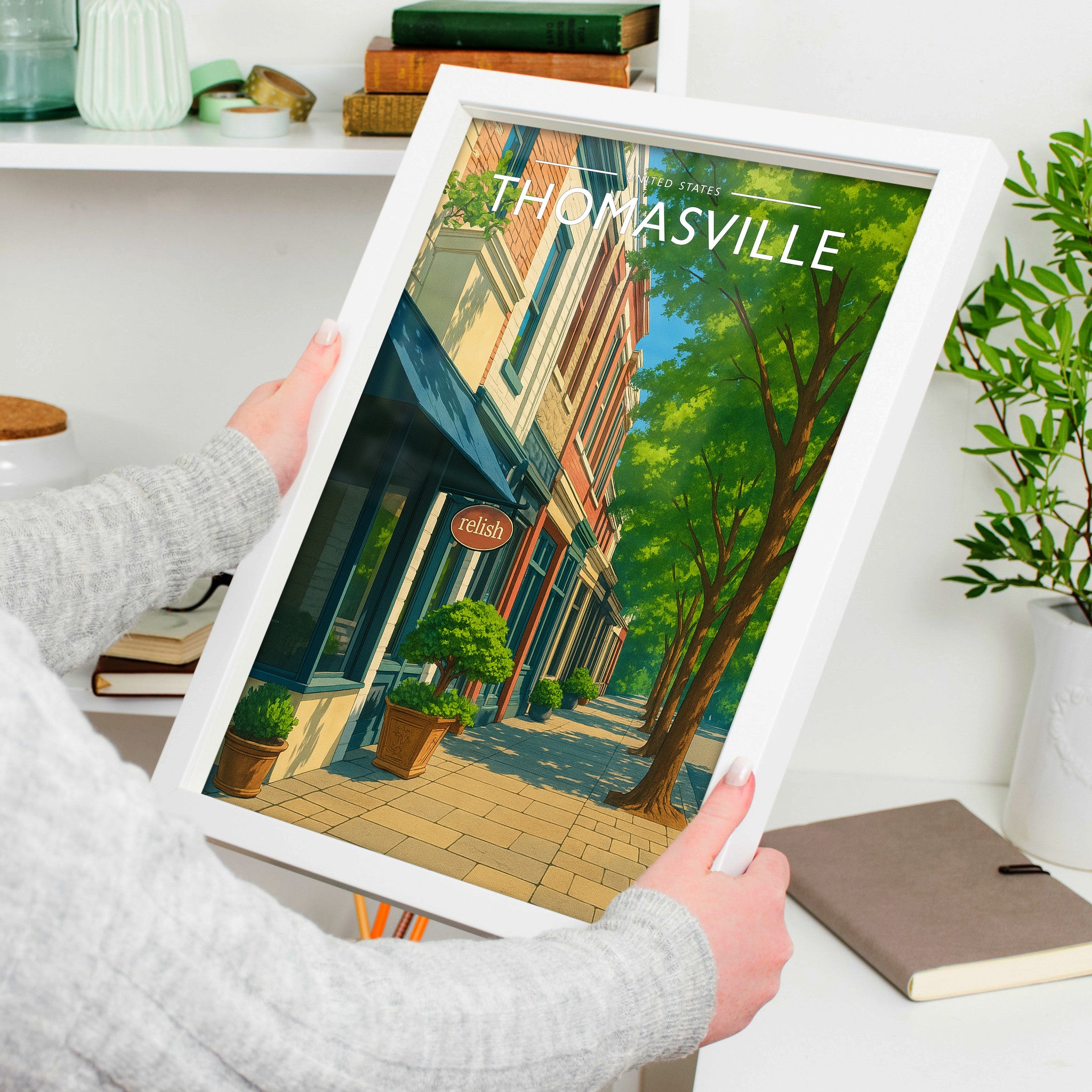 Thomasville Travel Poster in a white frame, held to show scale