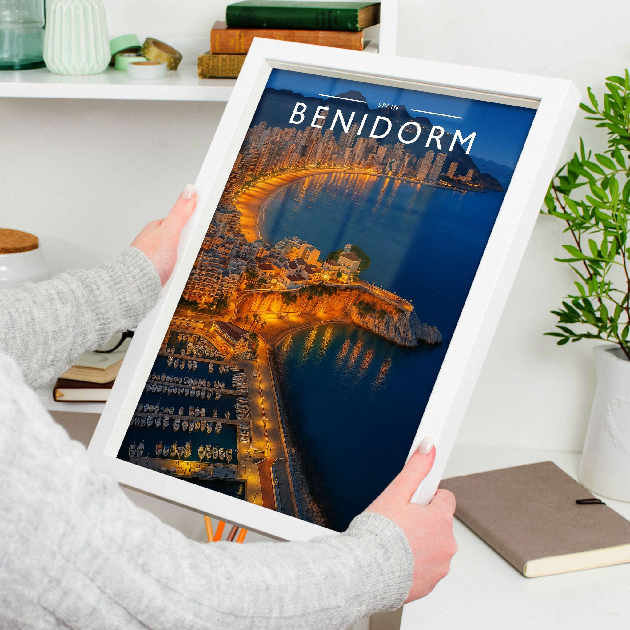 Benidorm Travel Poster in a white frame, held to show scale