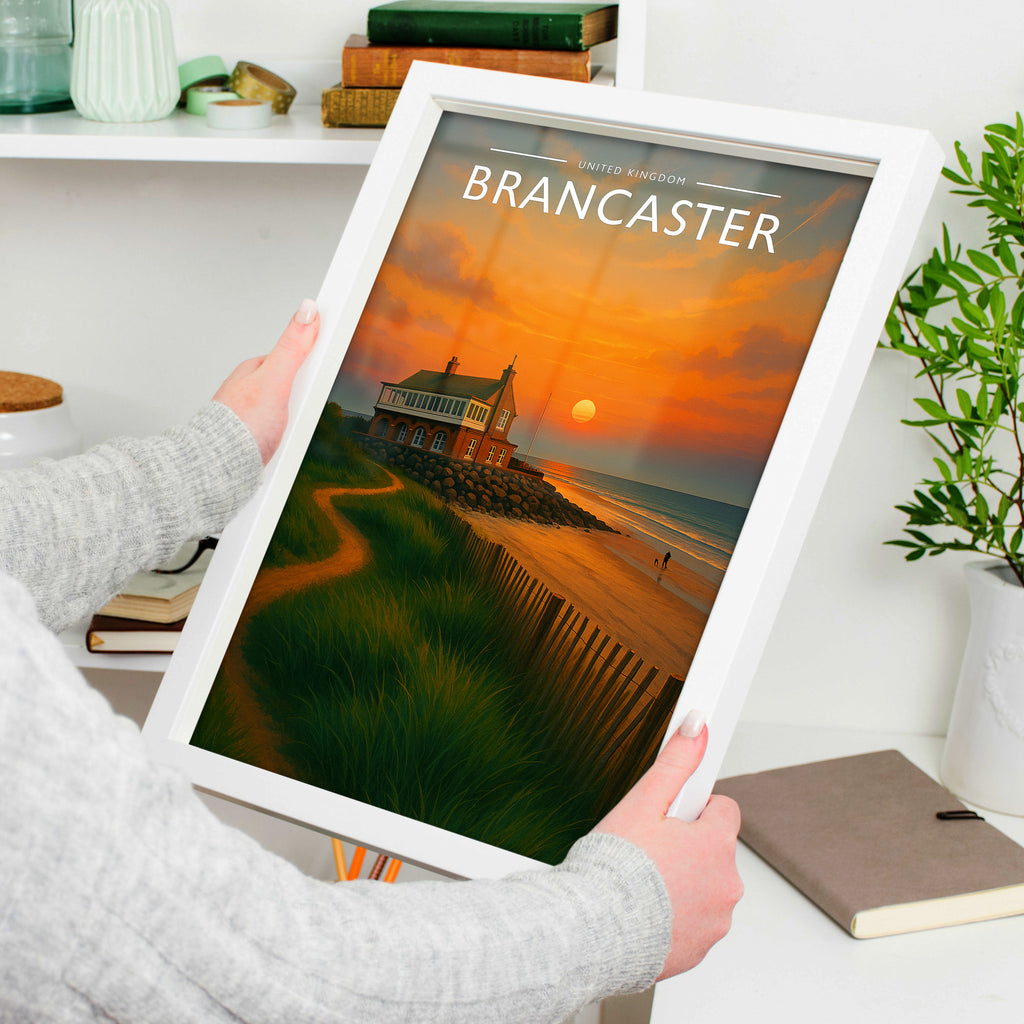 Brancaster Travel Poster in a white frame, held to show scale