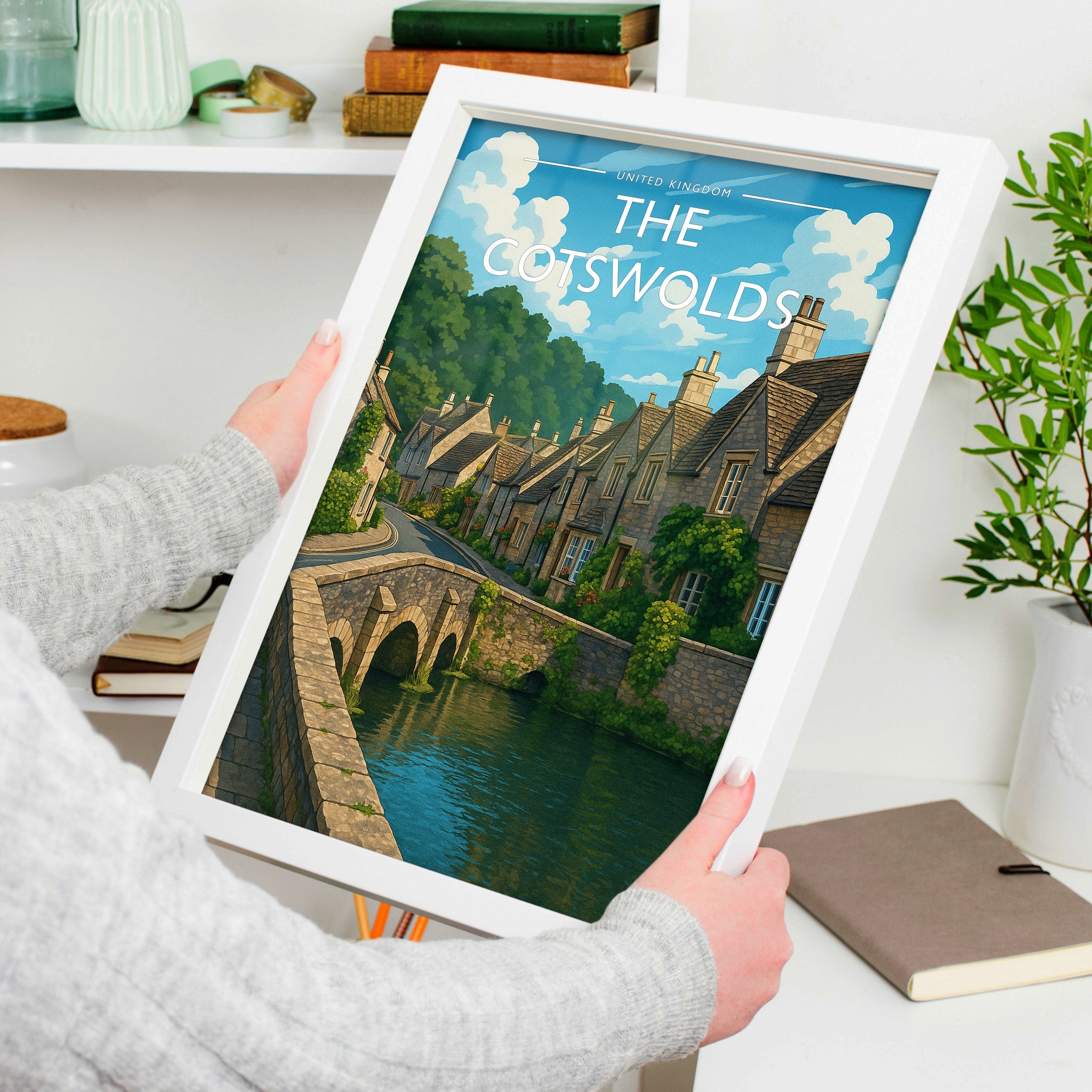 The Cotswolds Travel Poster in a white frame, held to show scale