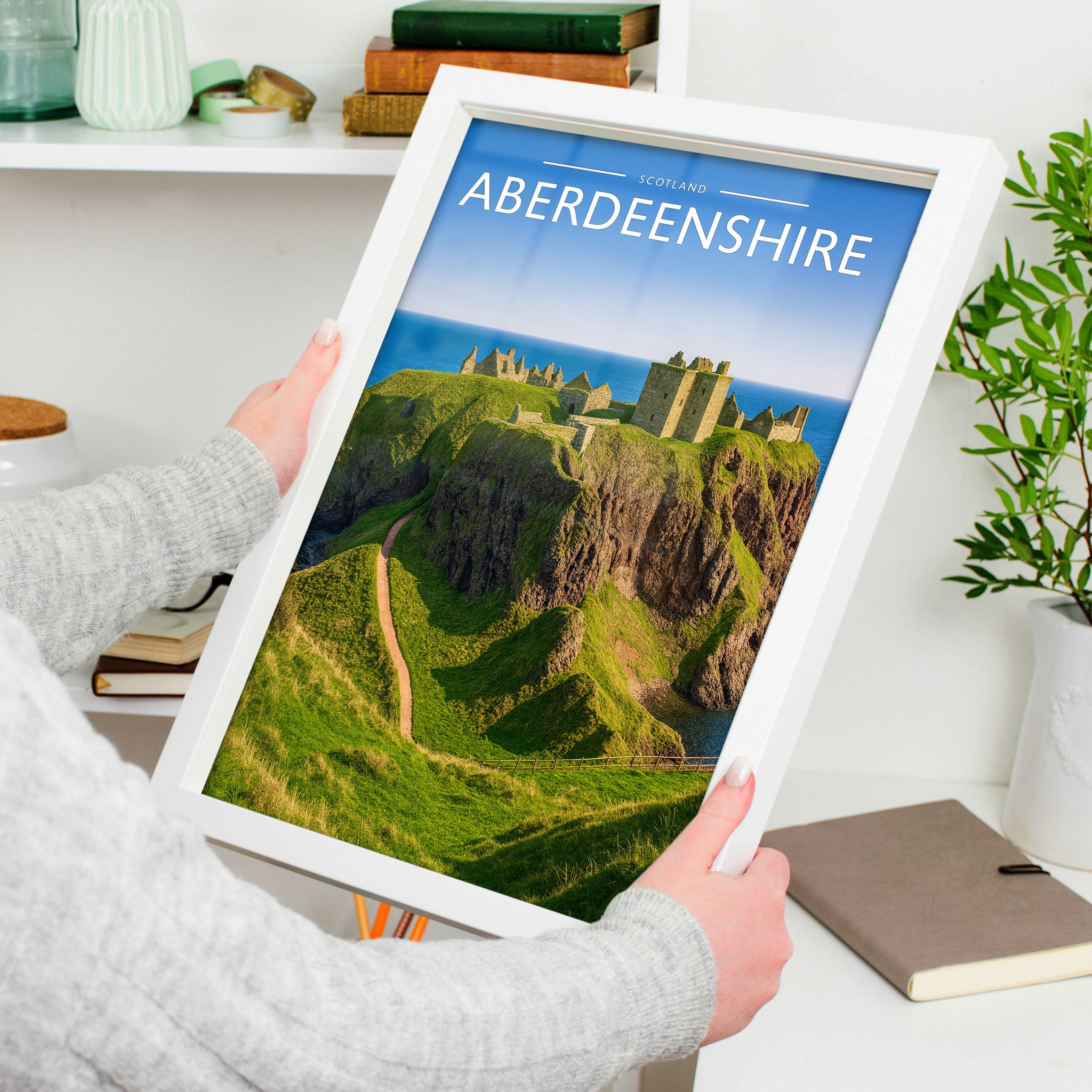 Aberdeenshire Travel Poster in a white frame, held to show scale