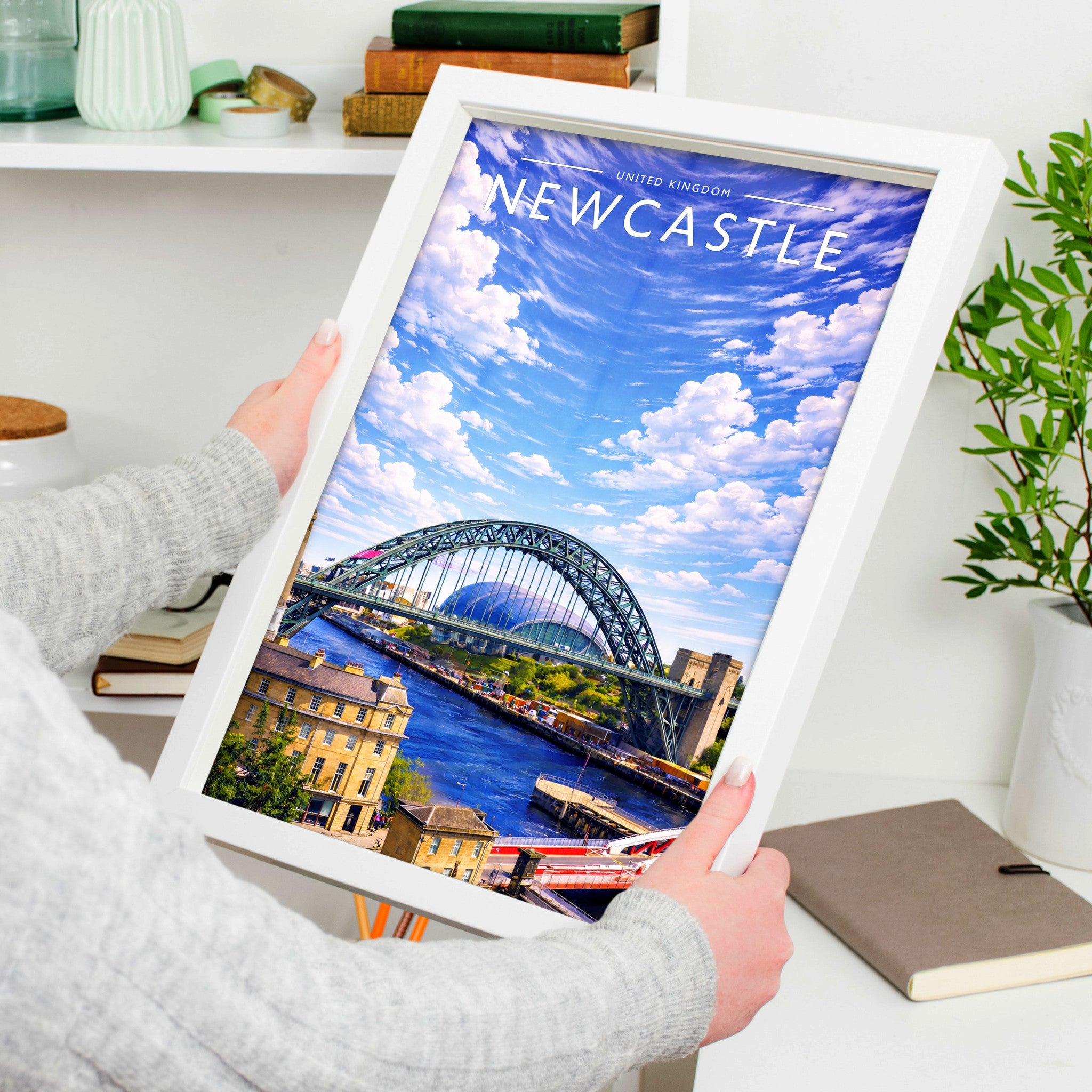 Newcastle Travel Poster in a white frame, held to show scale