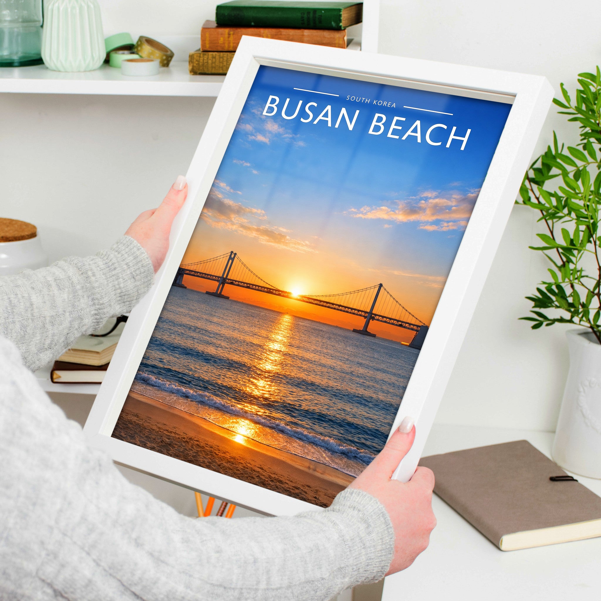 Busan Beach Travel Poster in a white frame, held to show scale