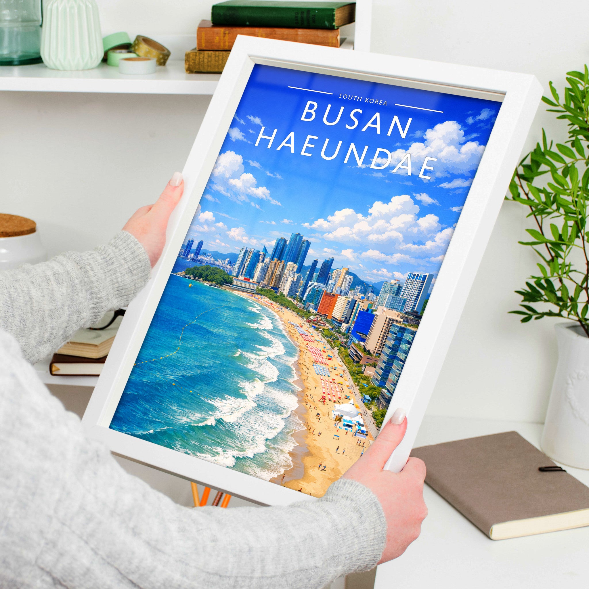 Busan Haeundae Travel Poster in a white frame, held to show scale
