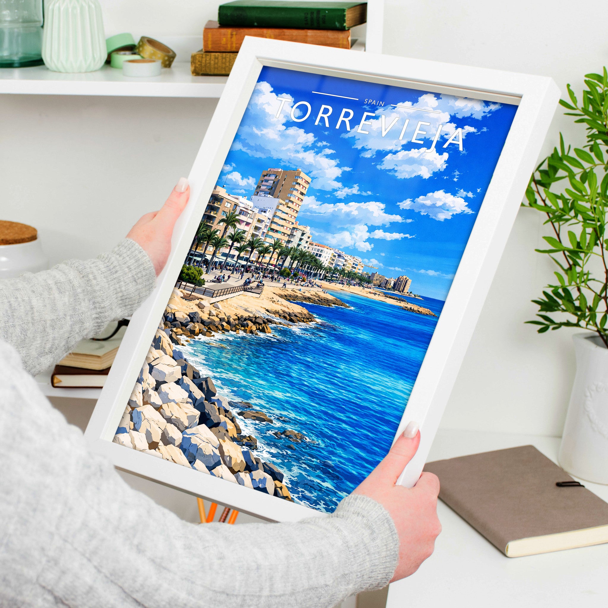 Torrevieja Travel Poster in a white frame, held to show scale