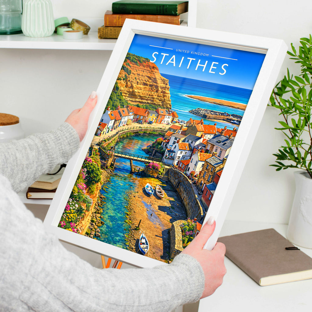 Staithes Travel Poster in a white frame, held to show scale