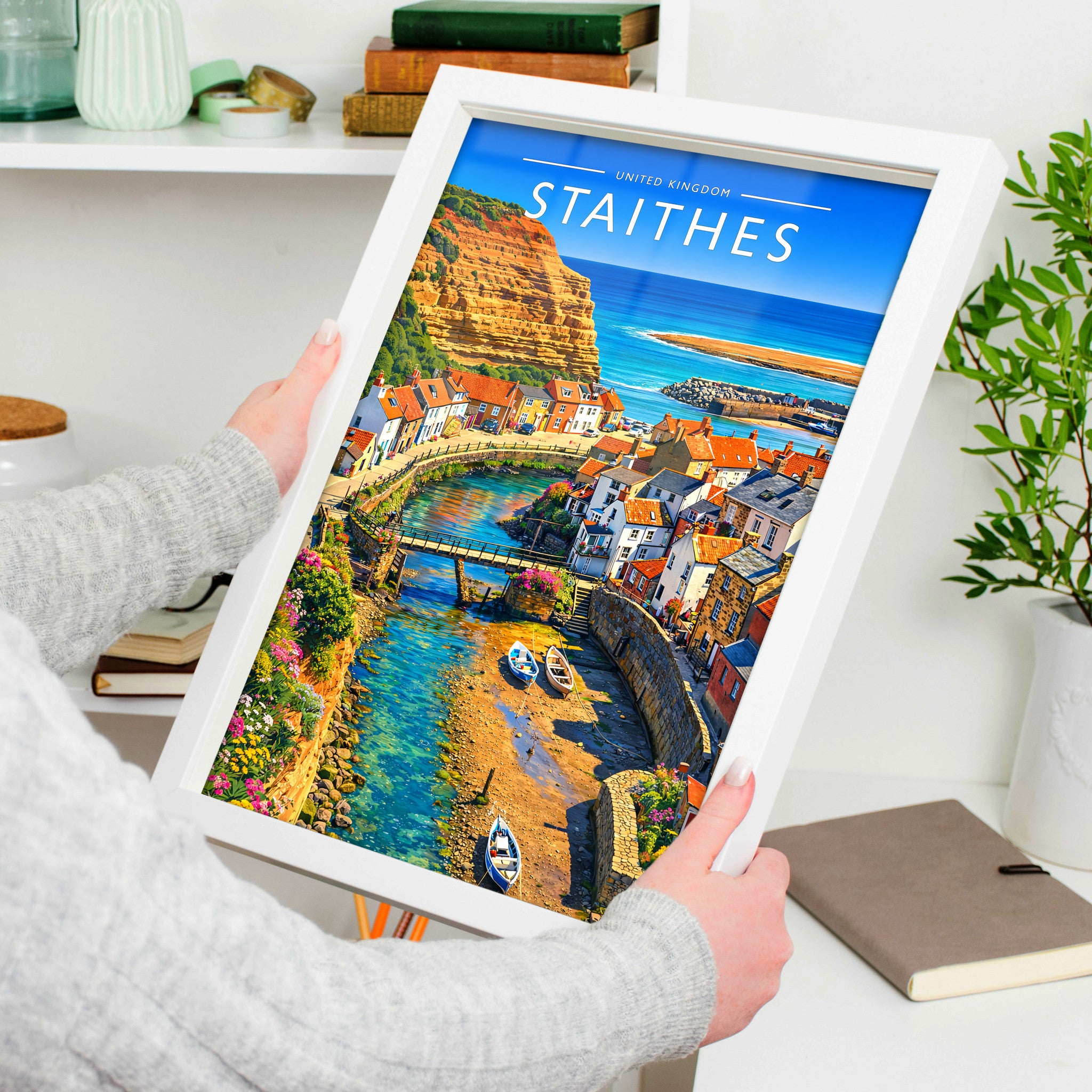 Staithes Travel Poster in a white frame, held to show scale