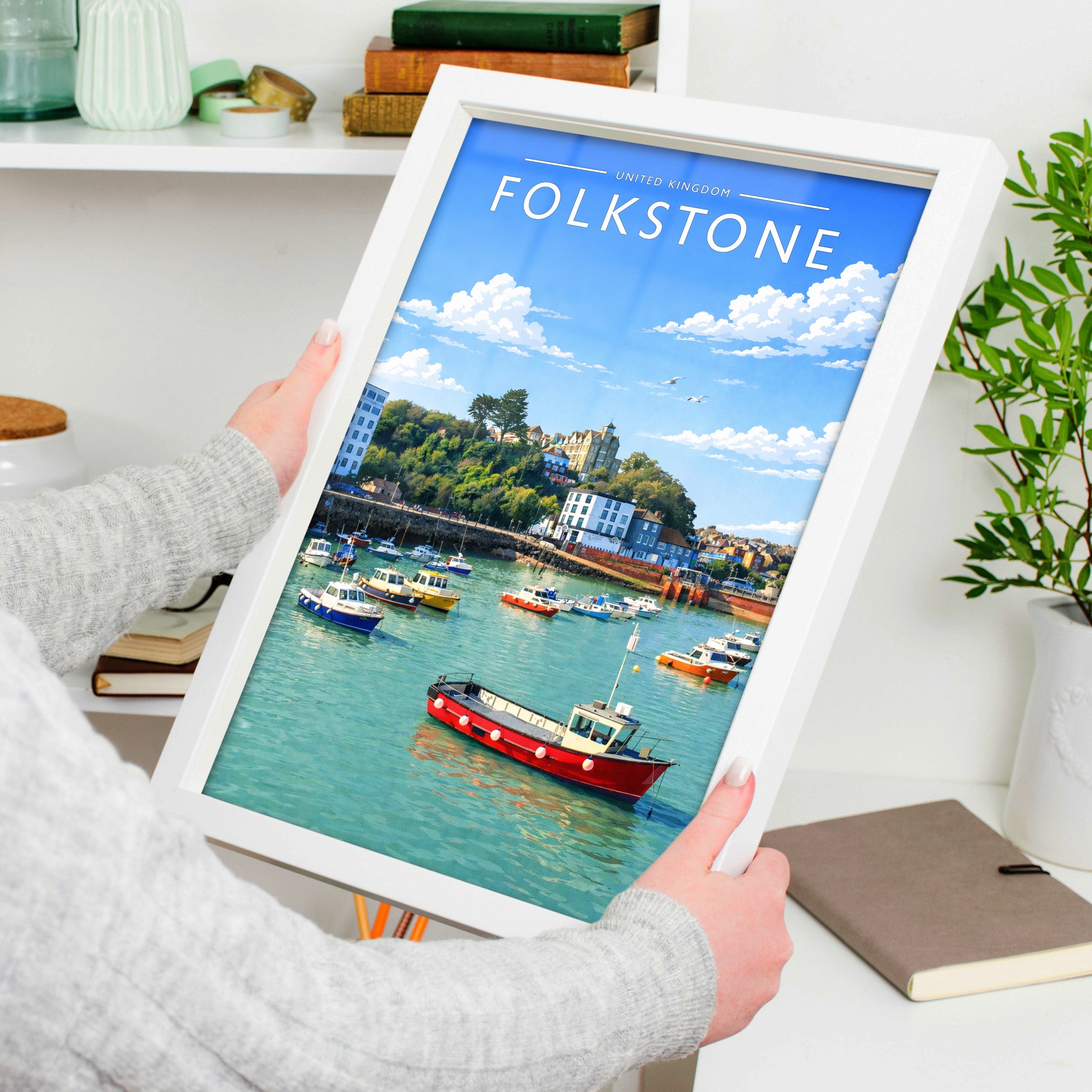 Folkestone Travel Poster in a white frame, held to show scale