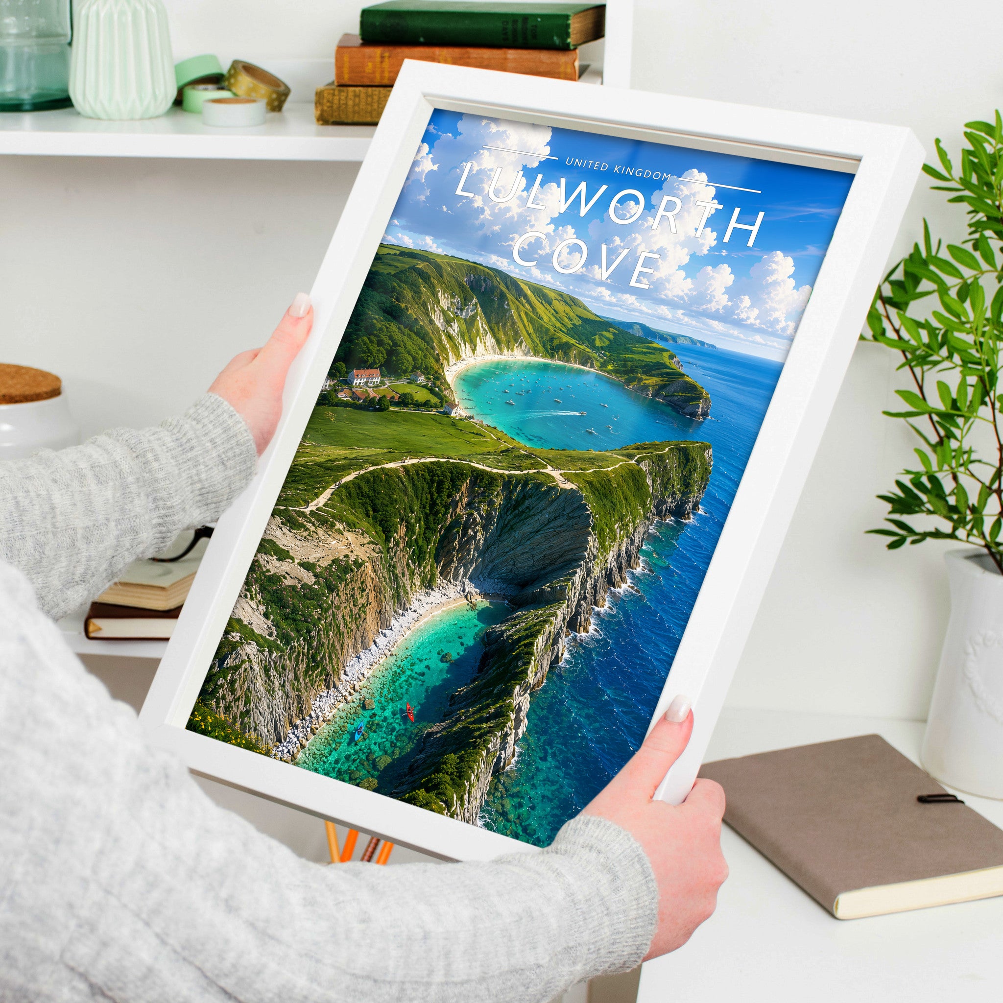 Lulworth Cove Travel Poster in a white frame, held to show scale