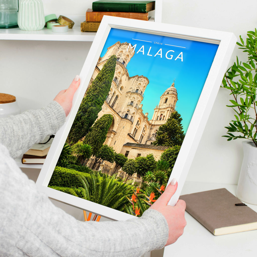 Malaga Travel Poster in a white frame, held to show scale