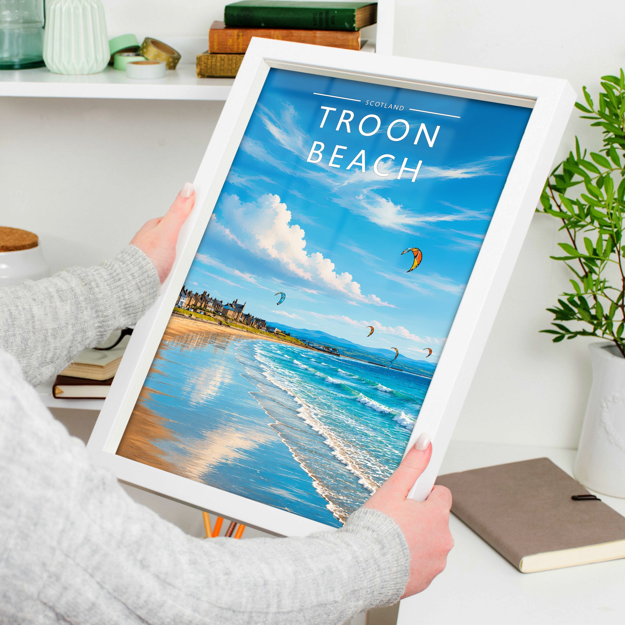 Troon Beach Travel Poster in a white frame, held to show scale