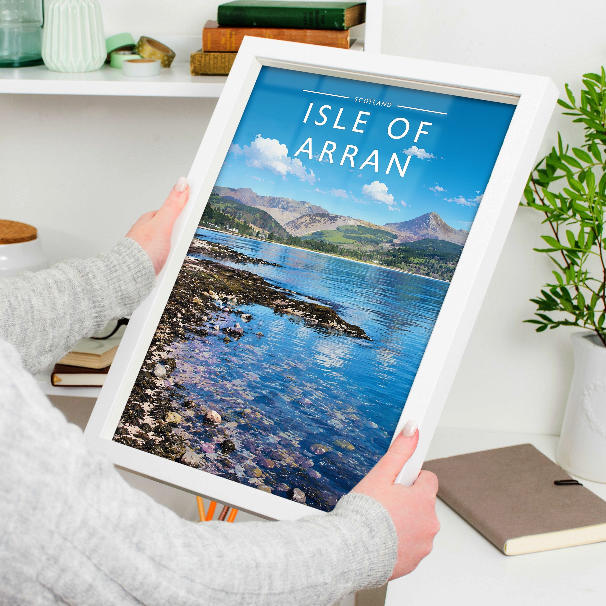 Isle of Arran Travel Poster in a white frame, held to show scale