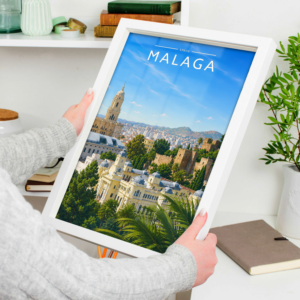 Malaga #2 Travel Poster in a white frame, held to show scale