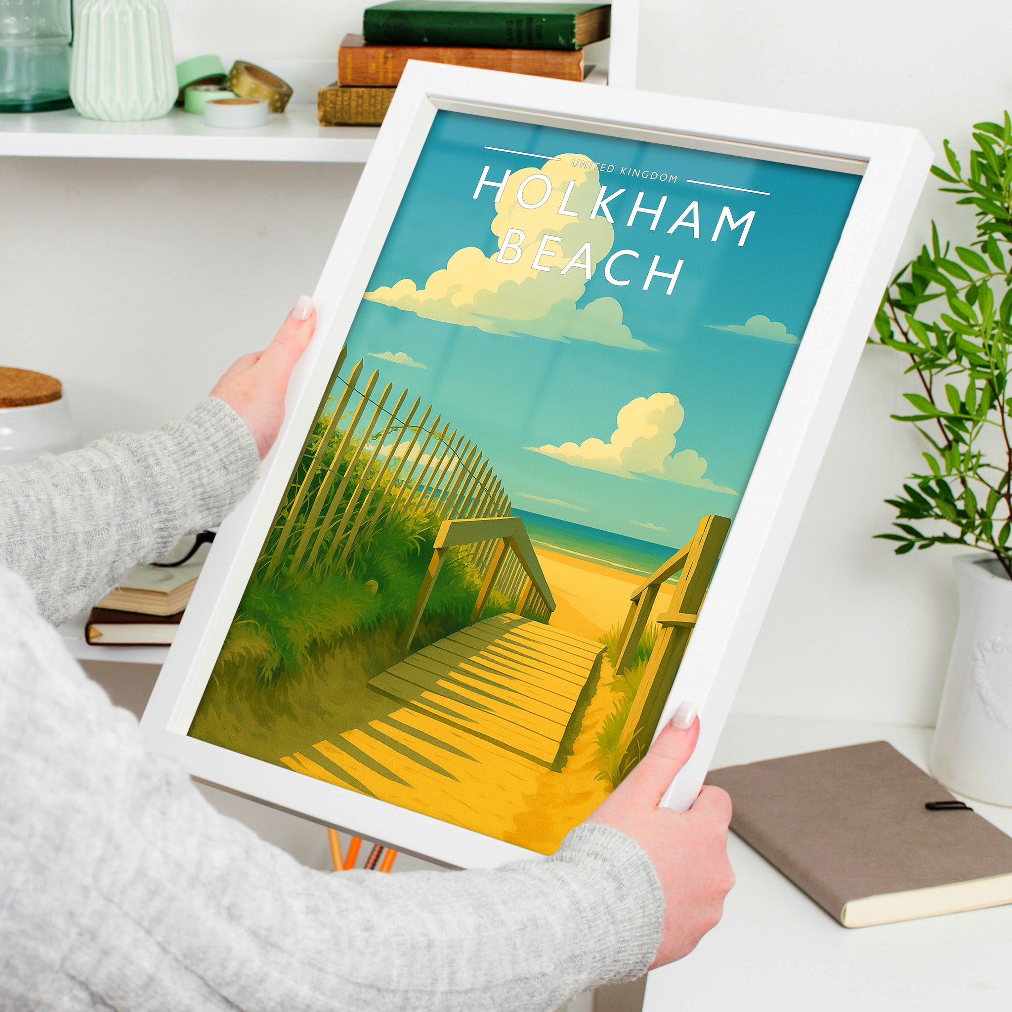 Holkham Beach Travel Poster in a white frame, held to show scale