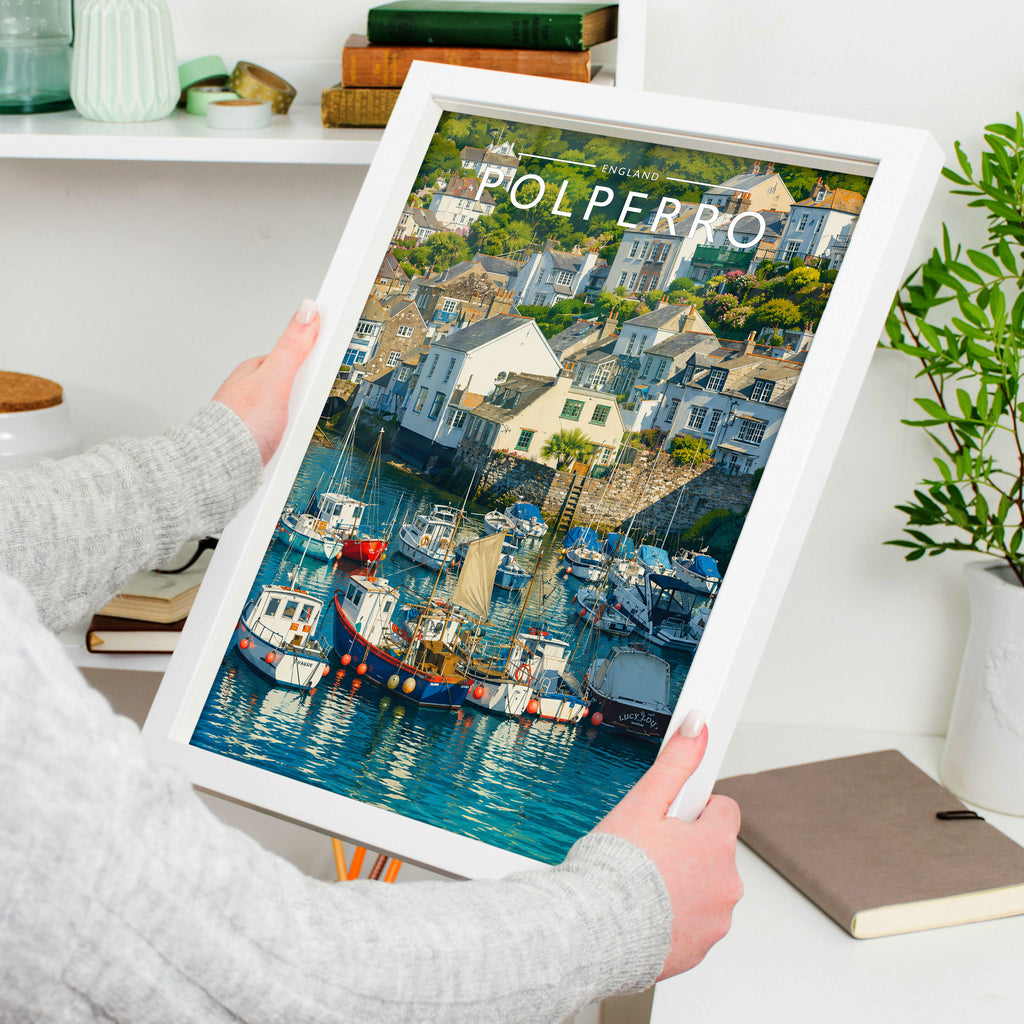 Polperro Travel Poster in a white frame, held to show scale