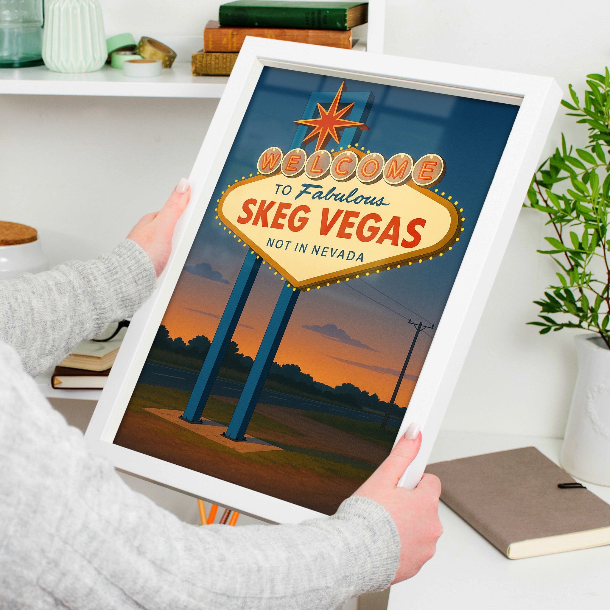 Skegness Travel Poster in a white frame, held to show scale