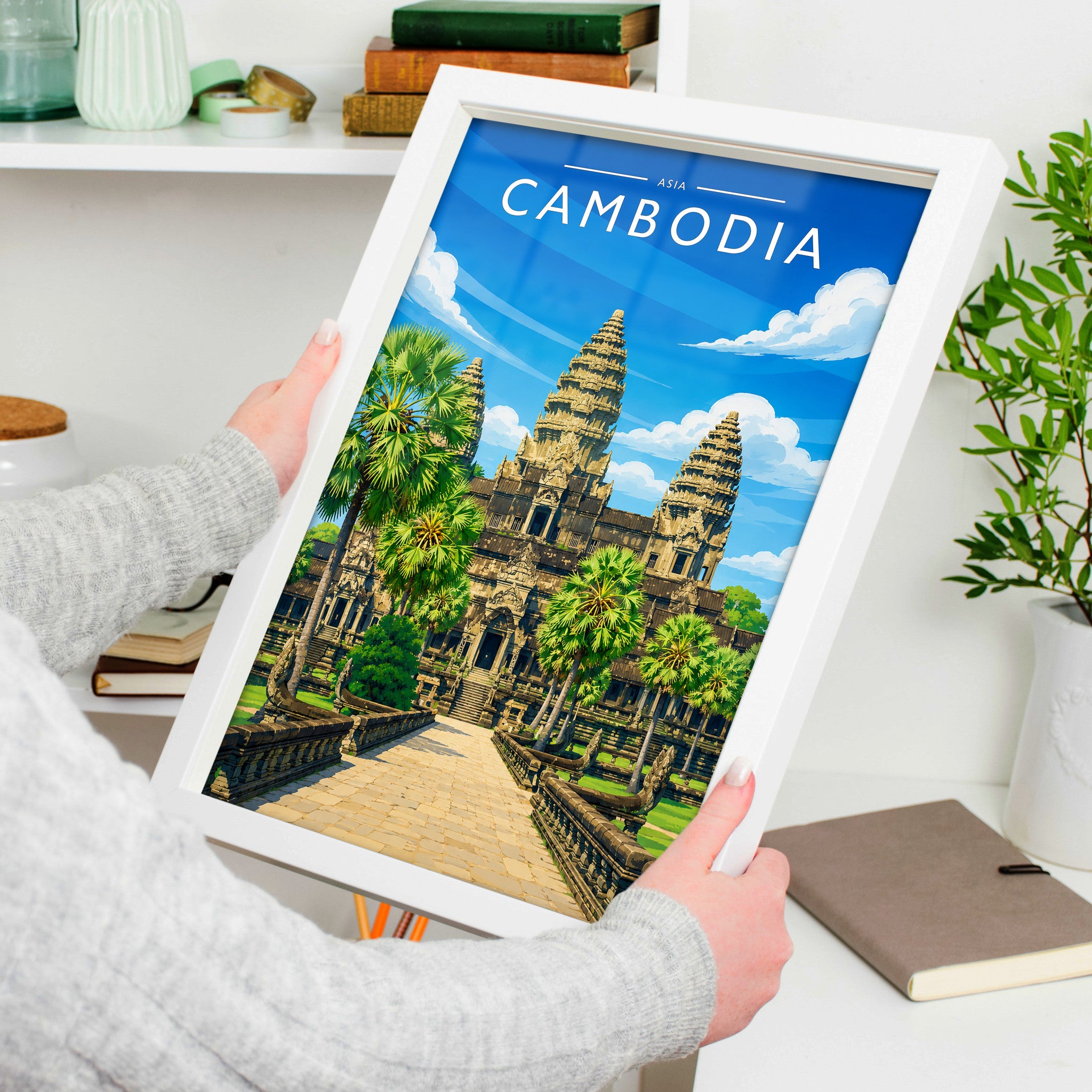 Cambodia Travel Poster in a white frame, held to show scale
