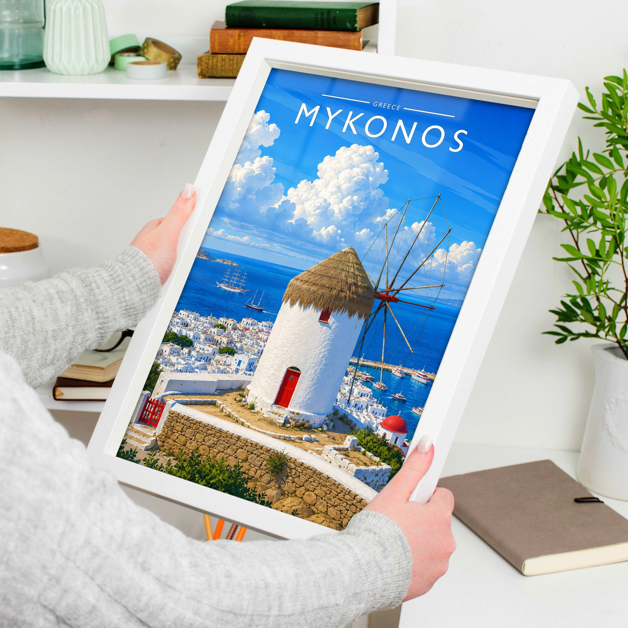 Mykonos #2 Travel Poster in a white frame, held to show scale