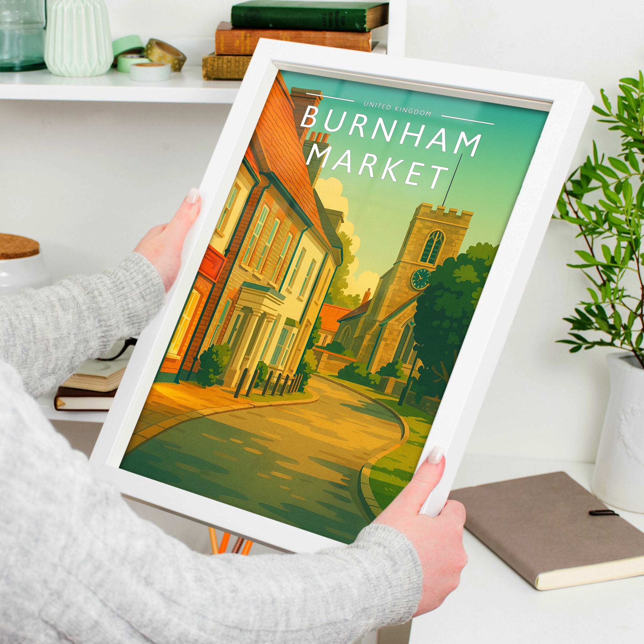 Burnham Market Travel Poster in a white frame, held to show scale