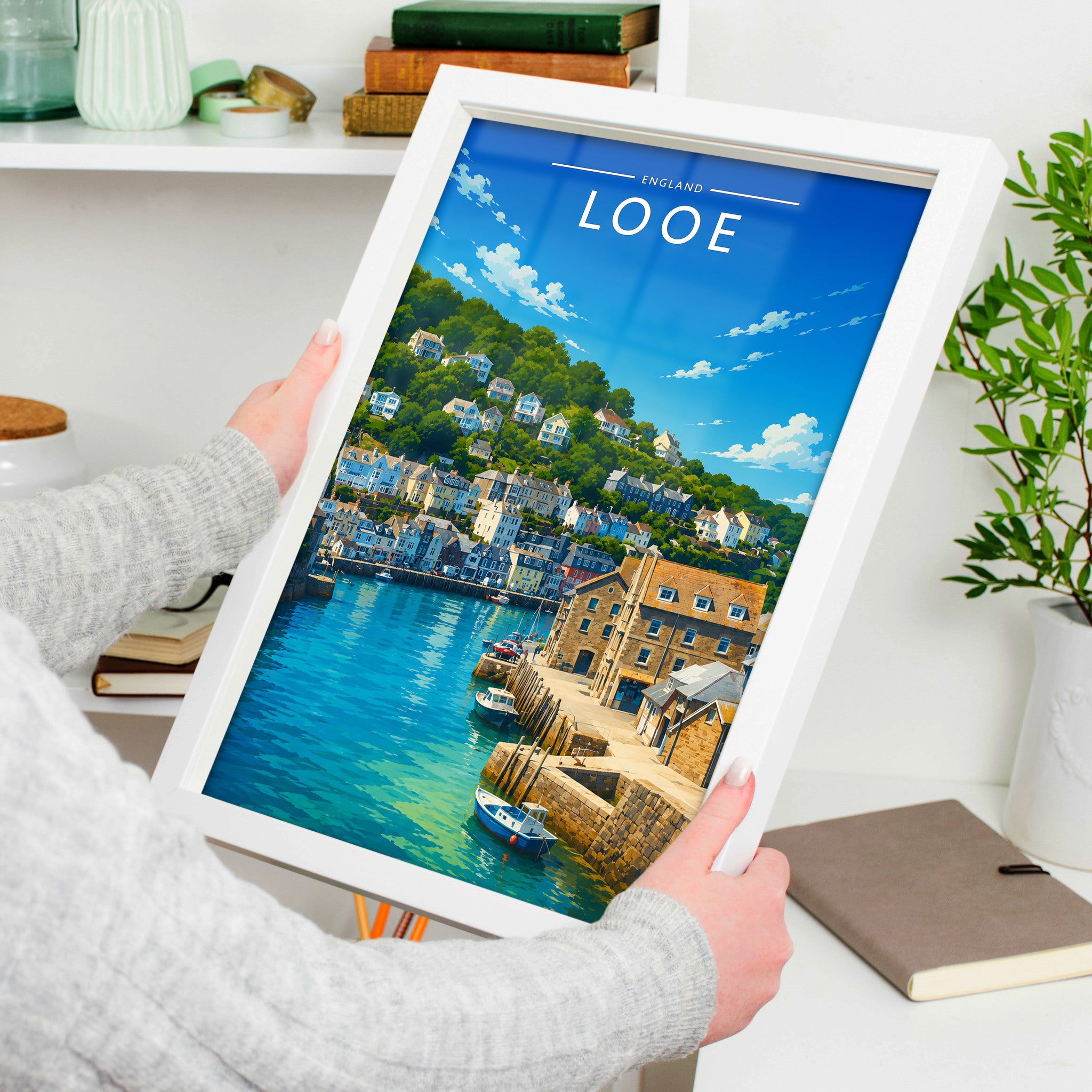 Looe Travel Poster in a white frame, held to show scale