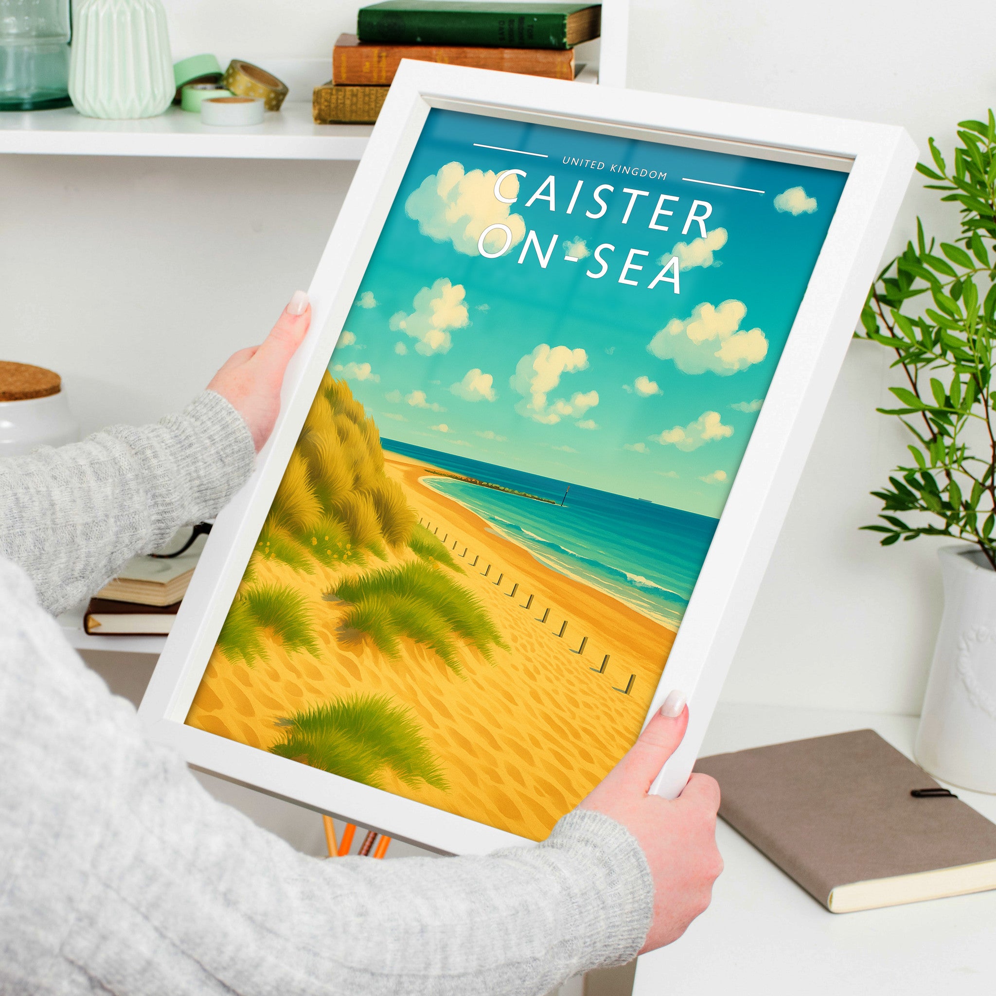 Caister-on-Sea Travel Poster in a white frame, held to show scale