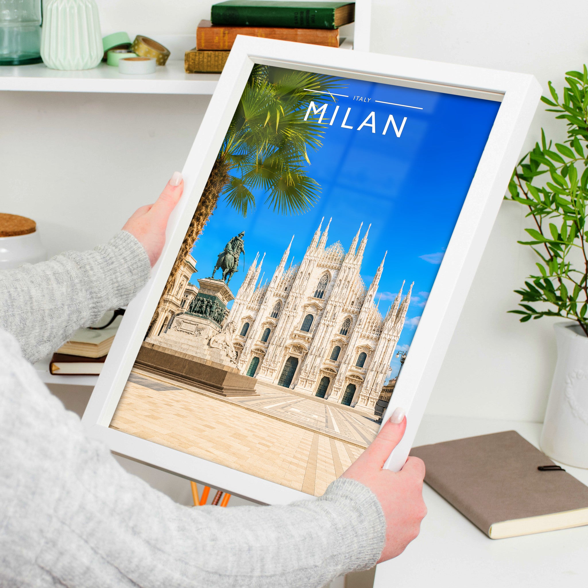 Milan Travel Poster in a white frame, held to show scale