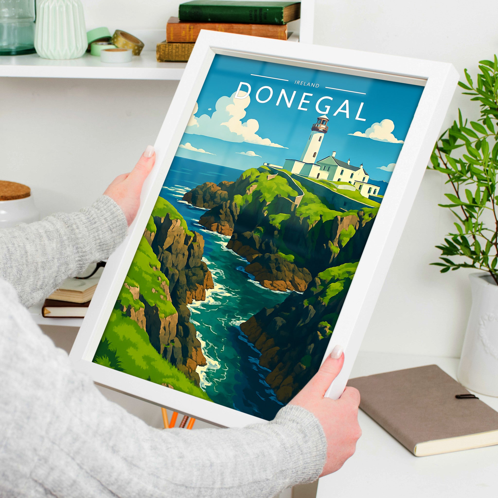 Donegal Travel Poster in a white frame, held to show scale