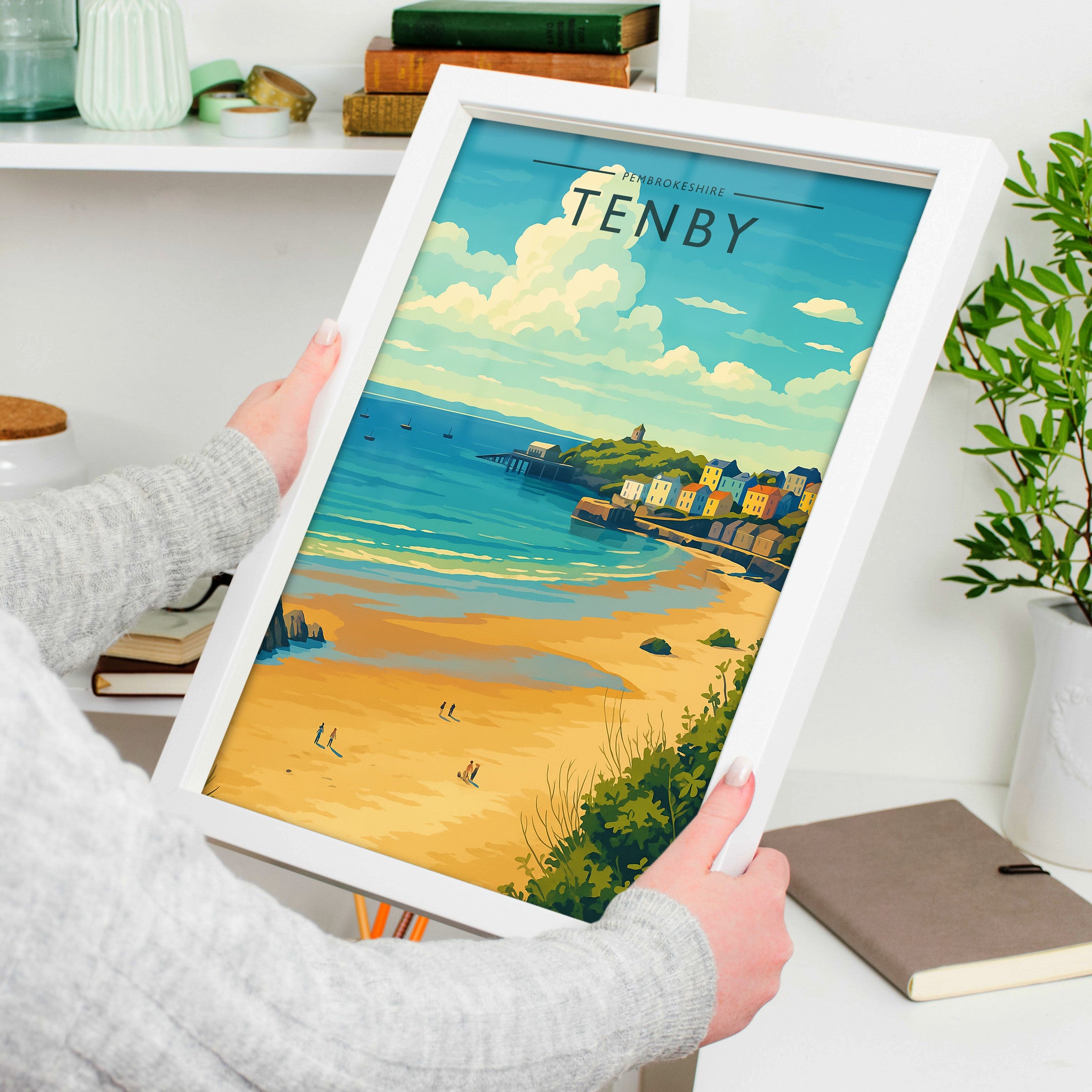 Tenby Travel Poster in a white frame, held to show scale