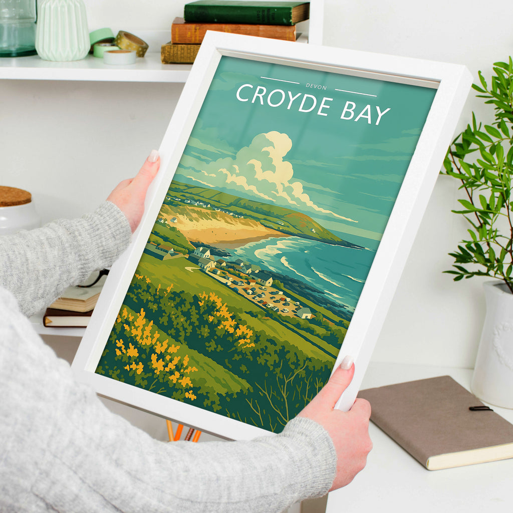 Croyde Bay Travel Poster in a white frame, held to show scale