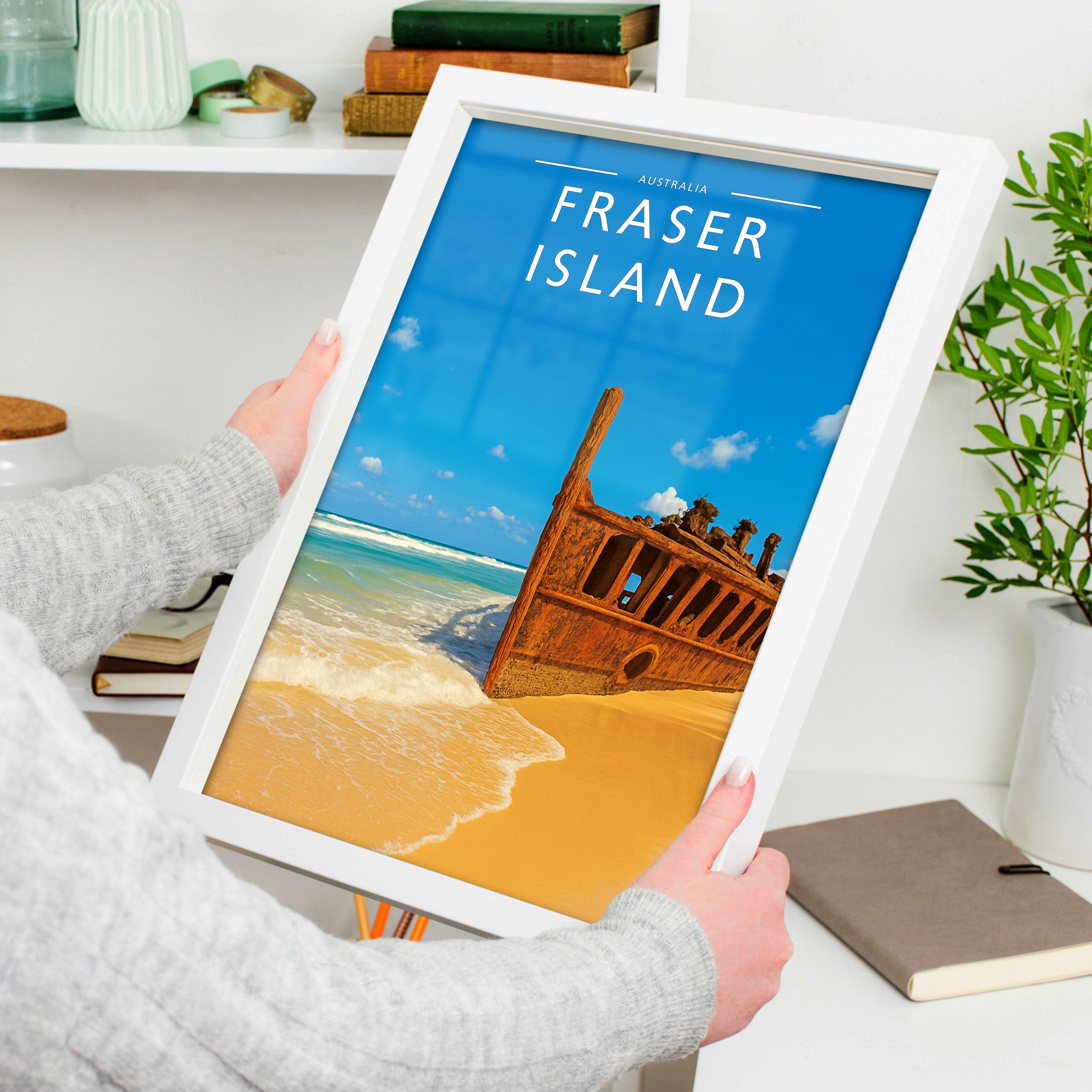 Fraser Island Travel Poster in a white frame, held to show scale