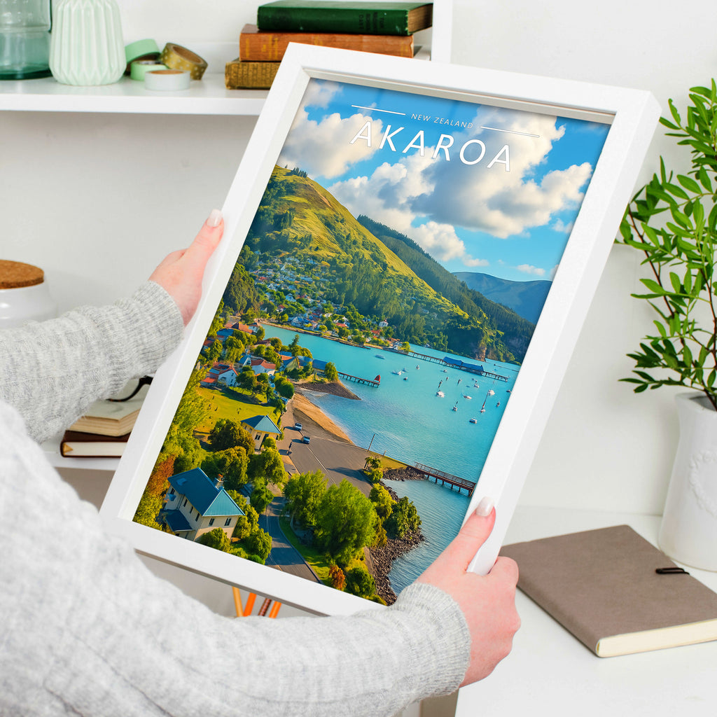 Akaroa Travel Poster in a white frame, held to show scale